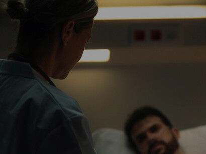 The doctor examines her patient, a look of sadness evident