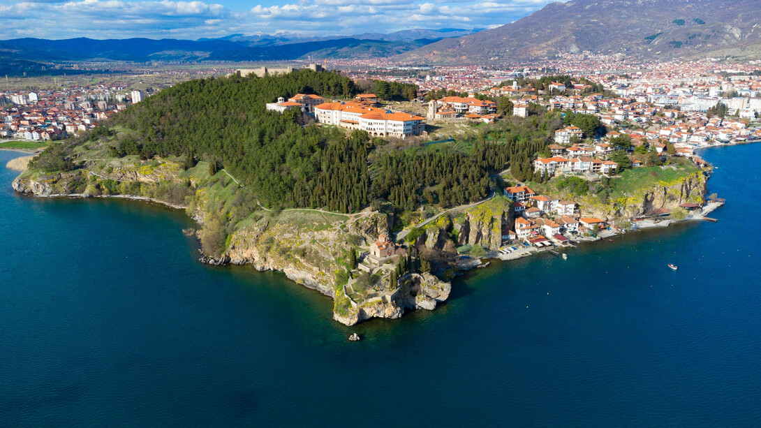 Scenic aerial view of Ohrid, North Macedonia, nestled amidst mountains and overlooking Lake Ohrid on a bright sunny day