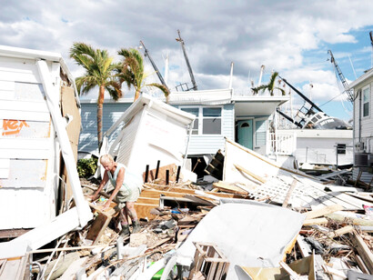 A female resident of San Carlos Island in Fort Myers Beach, Florida going through the debris of what is left of her home