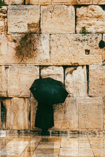 Woman with umbrella at wailing wall, Jerusalem, Israel
