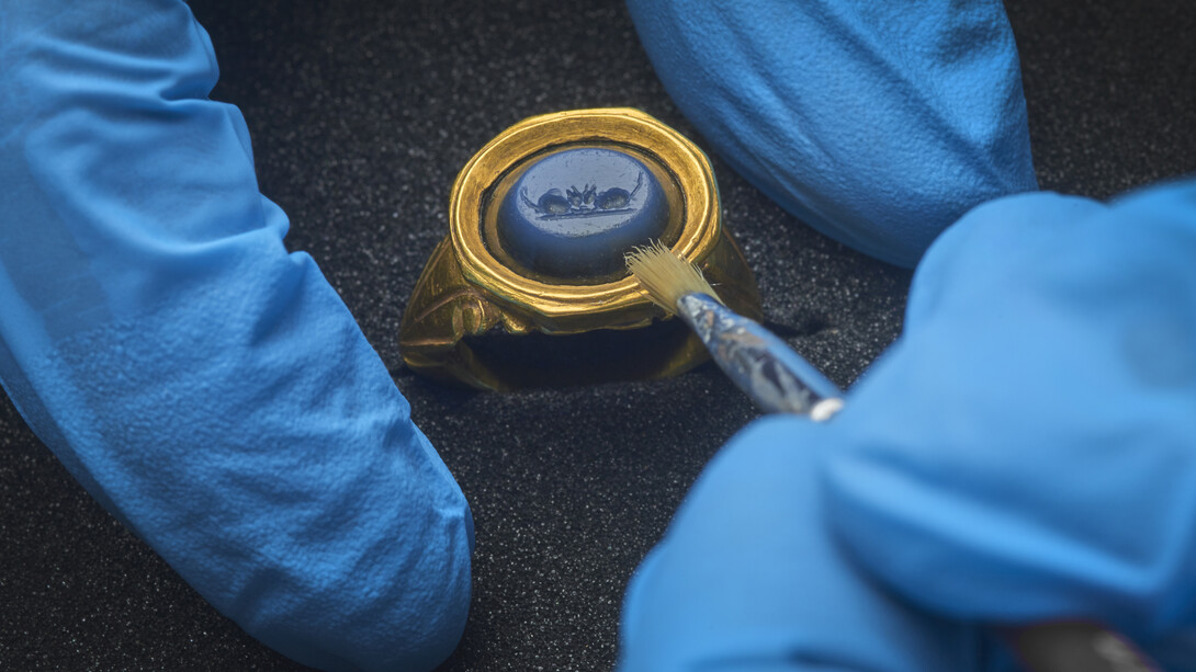 A gold ring with gemstone, depicting two mice eating together. This is a reference to a scene described in Horace’s Satires. © Museum of London 