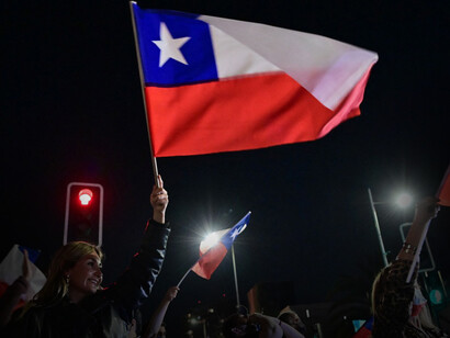 Mujer alza una bandera chilena por los resultados de la elección para el Consejo Constitucional en Santiago de Chile