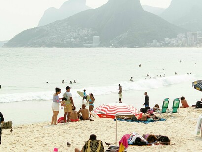 Praia do Rio de Janeiro. Minha alegria se transformou em pânico. Chamei por minha mãe, mas minha voz parecia pequena demais para superar o barulho ao redor. Andei de um lado para o outro, tentando voltar pelo mesmo caminho, mas tudo parecia igual. O sol começou a descer, tingindo o céu de laranja e roxo, e eu, um menino perdido, fui tomado por um medo que nunca havia sentido antes