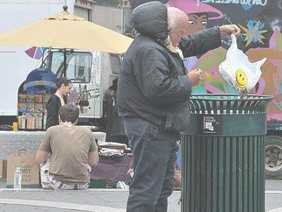 Man putting trash into the waste bin, New York City, USA