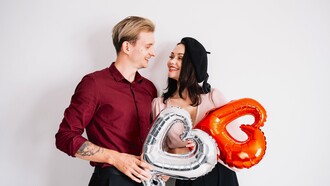 Casal segurando balões em forma de coração