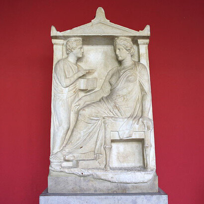 Estelas funerarias griegas antiguas de una mujer joven, a quien una joven esclava muestra la caja que contiene joyas de la ama. Museo Arqueológico Nacional de Atenas, Grecia