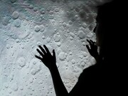 A woman examines a picture of the moon's surface