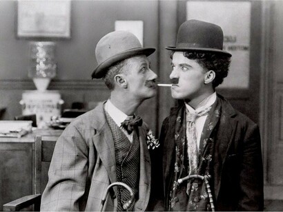 A black-and-white photograph of comedians Ben Turpin and Charlie Chaplin standing together in Los Angeles, USA
