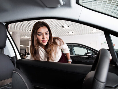Una joven mira el coche que nunca podrá comprar