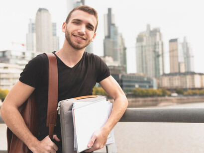 International student in a bustling city holding study notes, representing academic migration and student life