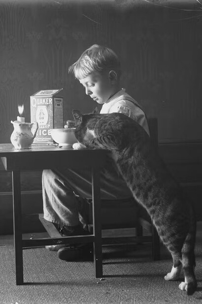 Willam Davis Hassler, William Gray Hassler seated at a small table eating Quaker Puffed Rice cereal, with Reddy the cat, ca- 1912. Courtesy of the New-York Historical Society Gallery