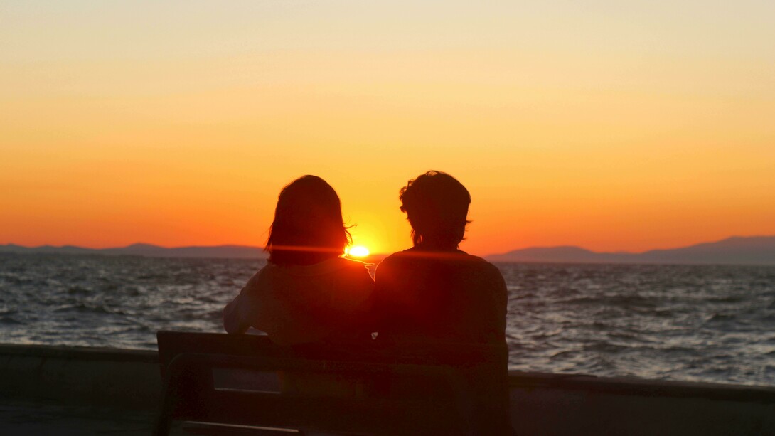 Casal assiste o atardecer juntos