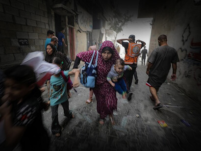 Madre coge a su hijo en brazos por la alarma de un bombardeo inminente en la región de Gaza
