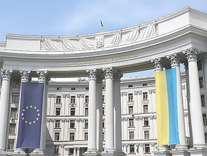 Capture the diplomatic alliance between Ukraine and the European Union through the sight of their flags flying high atop the Kiev Ministry of Foreign Affairs, symbolizing mutual cooperation and solidarity