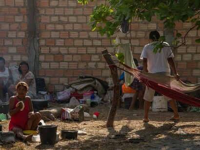 A woman cooks bread in an informal refugee camp for Indigenous Venezuelans in Boa Vista, Brazil
