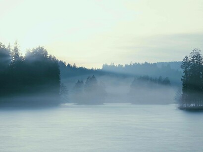 Luci dell'alba e foschia sulle acque placide di un lago: "Spiritus indica il vento, il respiro, il muoversi dell’aria"