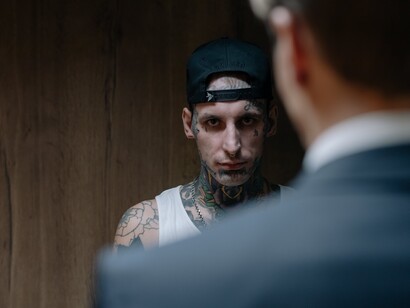Homem tatuado com olhar ameaçador