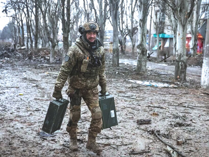 Soldado ucraniano recoge una munición en las cercanías de Kiev, Ucrania