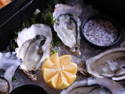 A lemon as center piece to accompany garnished oysters