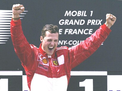 Michael Schumacher with arms raised in celebration after a victory in the French Grand Prix in Magny-Cours in France