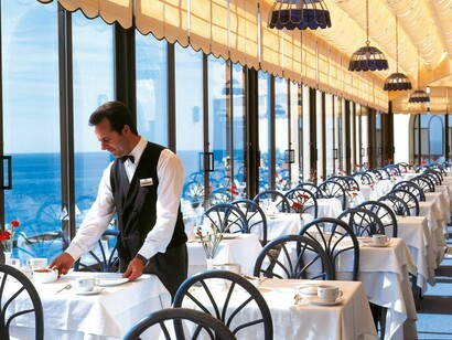 Un camarero prepara las mesas en el comedor de un hotel