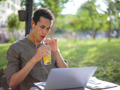 Focused male freelancer working on a laptop at a street caf