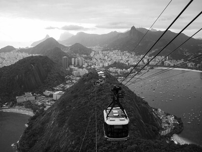 Bondinho do Pão de Açúcar, no Rio de Janeiro. Apesar de seu prestígio, o Rio deixou de ser capital do Brasil em 1960, com a fundação de Brasília. A perda do status político trouxe mudanças, mas a cidade manteve sua importância como centro econômico, cultural e turístico. As décadas seguintes foram marcadas por crescimento populacional desordenado, aumento das desigualdades, urbanização acelerada e conflitos urbanos, especialmente nas comunidades. A partir dos anos 1980, com a crise econômica e a violência urbana crescente, o Rio enfrentou desafios profundos, que continuam até hoje