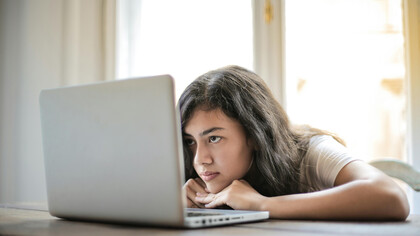 Adolescente lê tweets na rede X sobre um acontecimento em programa de TV em que os telescpectadores e usuários da internet estão julgando uma participante