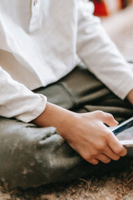 Mãoszinhas manuseiam tablet enquanto brinca com jogo