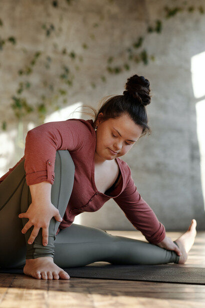 Garota com sindrome de down realiza uma postura de yoga