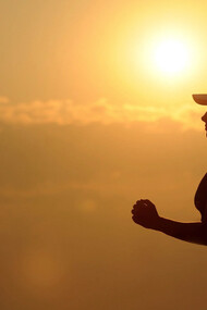 Ragazza motivata corre con il sole alle spalle che tramonta