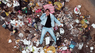 Man lying on garbage pile, Peru, Villa EL Salvador

