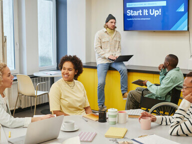 A man explains his ideas to the office team during a startup brainstorming session, as founders collaborate and prepare their pitch