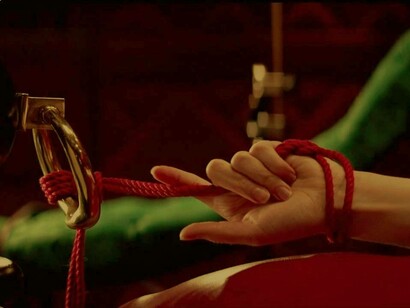 Anastasia Steele's hand is tied to a bedpost as she awaits her sexual fate in the movie "50 Shades of Grey"