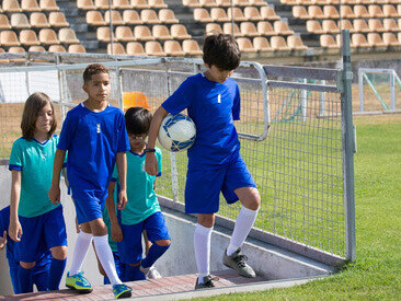A group of children climbing the stairs to the pitch for a youth football training session in Portugal