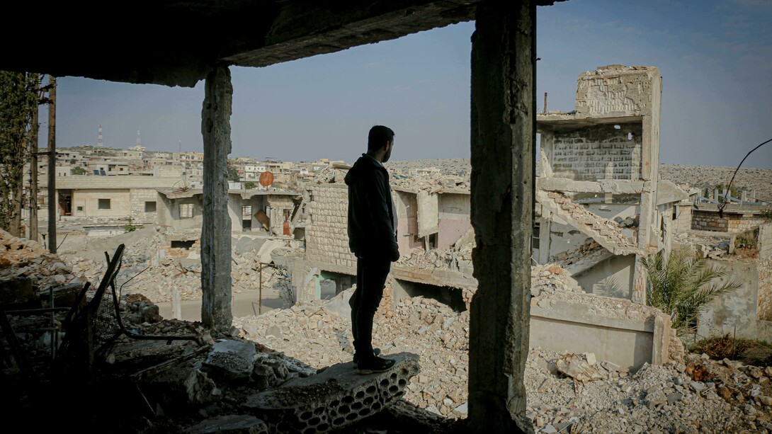 A man stands among the destroyed ruins of his hometown in Idlib, Syria