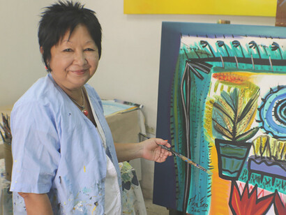 La artista cubana, Flora Fong, junto a una de sus obras