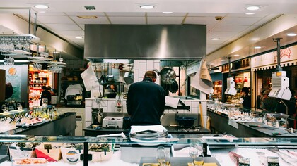 Uno chef che lavora in un mercato coperto