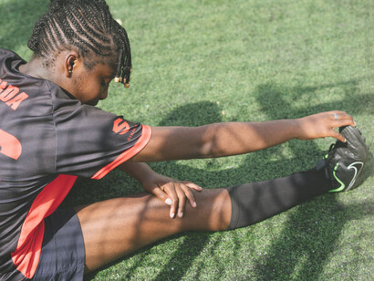 Jugadora de fútbol femenino elongando