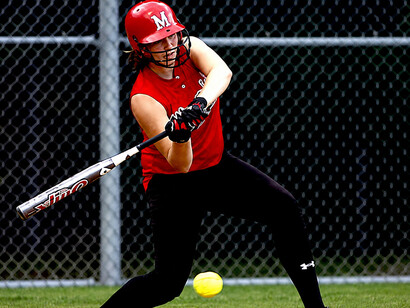 A woman holding a baseball bat during a women’s baseball match