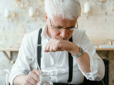 A man evaluates a fragrance by smelling it from a test tube during the perfume-making process