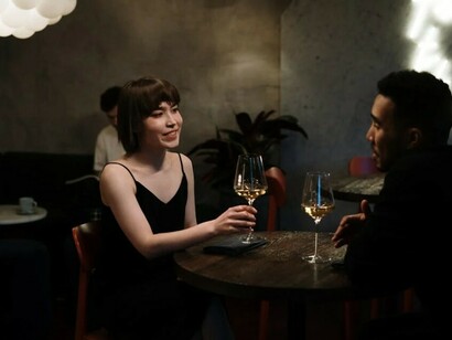 A man and a woman sipping wine together while on a date