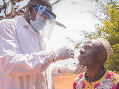 An African doctor conducts a COVID-19 test on an elderly patient using a swab, showcasing proactive testing efforts amidst the pandemic in Africa