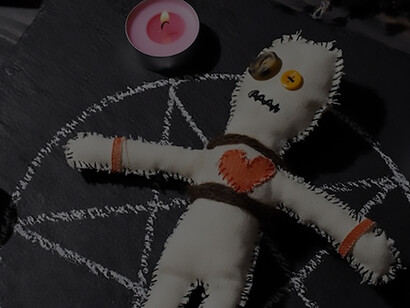 An arrangement featuring a voodoo doll surrounded by candles