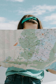 A woman holding a map, puzzled about what to do next