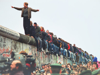 Personas sentadas en los alto del Muro de Berlín el día de su caída el 9 de noviembre de 1989, Berlín, Alemania