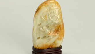 Montaña de jade con soporte: nefrita de color blanco verdoso con manchas de color marrón anaranjado talladas en el anverso para representar un mono sosteniendo la inmortalidad del melocotón y sentado debajo de un árbol en el que crecen los melocotones y soporte de palisandro de cuatro patas. Cobertizo de piedra en las montañas