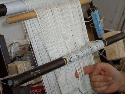 Hiladora mostrando la estructura de alfombra iraní