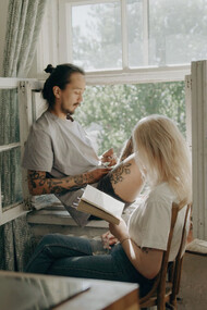 Embracing the simplicity of an unplugged day, the two find solace in shared moments of quietude and literary exploration