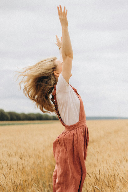 A woman standing in a vast wheat field, reflecting a journey of change, self-growth, and personal renewal